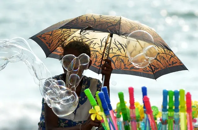 A Sri Lankan vendor sells bubble liquid on the Galle Face promenade in the heart of the Sri Lankan capital of Colombo on April 19, 2015. (Photo by Ishara S. Kodikara/AFP Photo)