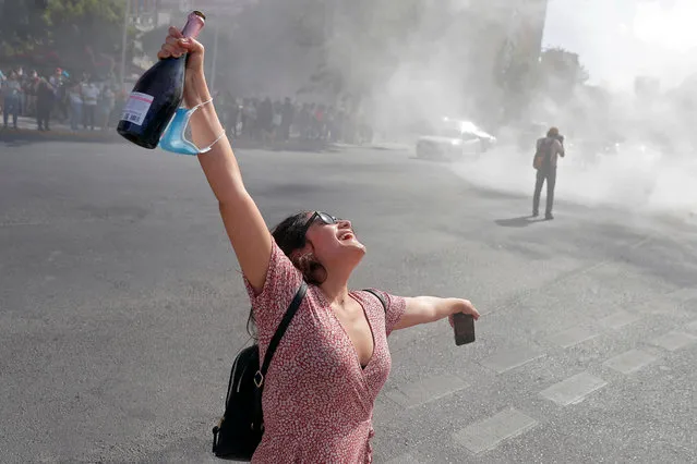 A woman holds a bottle as she celebrates after the announcement of the Chilean press of the death of Chilean dictator (1973-1981) Augusto Pinochet's widow Lucia Hiriart, at plaza Italia in Santiago on December 16, 2021. Lucia Hiriart, 98, widow of former Chilean dictator Augusto Pinochet, died Thursday afternoon at the residence where she lived in the company of all her children and grandchildren, her family confirmed. (Photo by Javier Torres/AFP Photo)