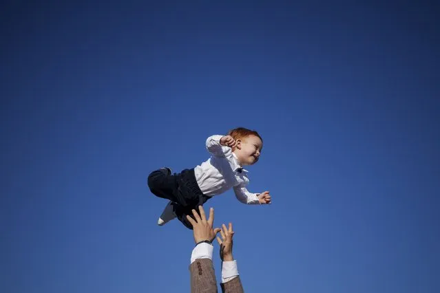 A Muslim man playfully throws a baby in the air at the end of Eid al-Fitr prayers in Bucharest, Romania, Wednesday, April 10, 2024. Members of the Romanian Muslim community joined prayers at the Dinamo stadium in the Romanian capital, in the largest Muslim public gathering of the year. Eid al-Fitr marks the end of the holy fasting month of Ramadan. (Photo by Andreea Alexandru/AP Photo)