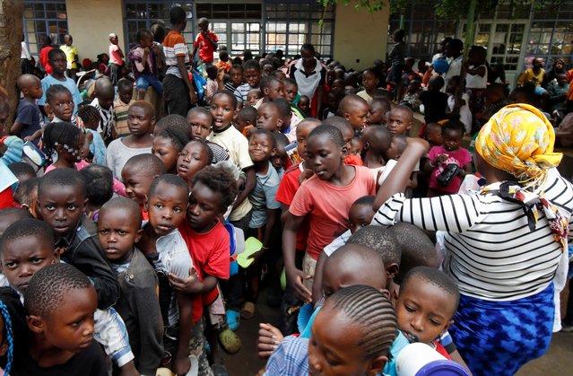 Displaced children queue for food rations at a rescue centre after the Nairobi river burst its banks and destroyed their homes within the Mathare valley settlement in Nairobi, Kenya on April 30, 2024. (Photo by Monicah Mwangi/Reuters)