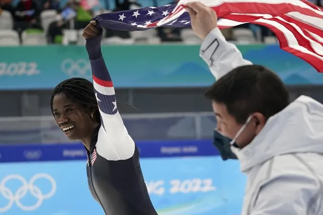 Erin Jackson of the United States holds up an American flag with coach Ryan Shimabukuro after winning the gold medal in the speedskating women's 500-meter race at the 2022 Winter Olympics, Sunday, February 13, 2022, in Beijing. (Photo by Ashley Landis/AP Photo)