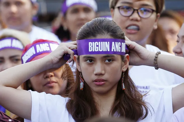 In this March 8, 2018, file photo, a protester adjusts her headband reading “Frustrate the dictatorship!” during a rally at a Manila square to mark International Women's Day which largely turns out to be an anti-government event in Manila, Philippines. The Philippine president signed Tuesday, July 16, 2019 a bill into law penalizing a range of acts of sexual harassment including catcalling, wolf-whistling and persistent telling of sexual jokes, which pro-women's groups have accused him of committing. (Photo by Bullit Marquez/AP Photo/File)