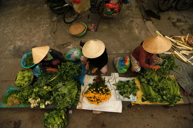 Women wearing traditional hats, known as a non la, sit in a market in Hoi An, Vietnam April 5, 2016. (Photo by Jorge Silva/Reuters)