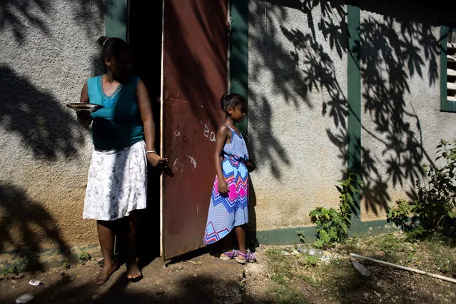 In this August 17, 2016 photo, Marie-Ange Haitis, 40, stands with her daughter, Samantha, at their home in Leogane, Haiti. Haitis says she met a Sri Lankan commander in December 2006 and he soon began making nighttime visits to her house. “By January, we had had s*x”, she said. “It wasn’t rape, but it wasn’t exactly consensual, either. I felt like I didn’t have a choice”. Haitis says Samantha has started asking more questions about her father. (Photo by Dieu Nalio Chery/AP Photo)