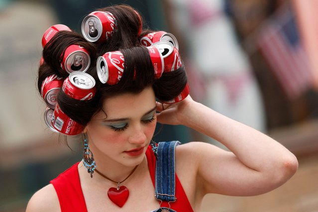 Lianah Flores with Coca Cola cans in her hair attends the Fourth of July Independence Day holiday parade during hot weather in Huntington Beach, California on July 4, 2024. (Photo by Etienne Laurent/Reuters)