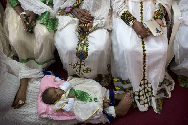 In this Saturday, April 23, 2016 photo, Eritrean Christian Orthodox migrant women attend a mass at a makeshift church in Tel Aviv, Israel. Hundreds of faithful gather each week in the makeshift churches. With its walls bedecked with Christian paraphernalia, it is an unlikely scene in the heart of the Jewish state, hidden in a non-descript buildings in hardscrabble south Tel Aviv. (Photo by Oded Balilty/AP Photo)