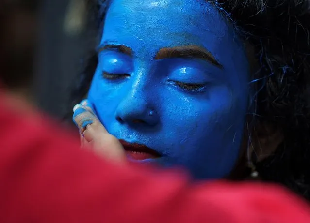 A student has her face painted before taking part in a cultural event to mark the Hindu festival of Janmashtami, or the birth anniversary of Hindu Lord Krishna, inside a college in Mumbai, August 21, 2019. (Photo by Hemanshi Kamani/Reuters)