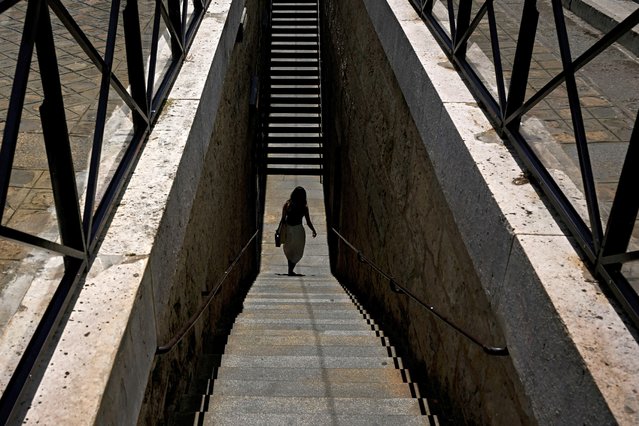 A woman walks in the streets of Paris, on June 28, 2024. (Photo by Julien de Rosa/AFP Photo)