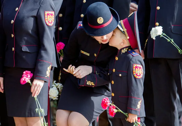 A boy with his mother pictured in the line of officers during celebrations to mark the 72th anniversary of Victory Day, at the Victory Memorial in Chisinau, Moldova, 09 May 2017. Former Soviet Republics on 09 May celebrate the 72th anniversary of the victory of the Soviet Union's Red Army and its allies over Nazi Germany in WWII. (Photo by Dumitru Doru/EPA)