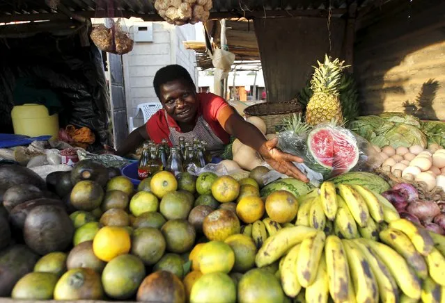 Imelda Akinyi, 25, arranges fruits at her stall in the trading centre of Kogelo, west of Kenya's capital Nairobi, July 14, 2015. Akinyi said, “President Obama is our son, he clearly knows his roots and he identifies himself with us”. “We want him to help us get a modern supermarket in Kogelo and find markets for our fruit and vegetables overseas”, she added. (Photo by Thomas Mukoya/Reuters)