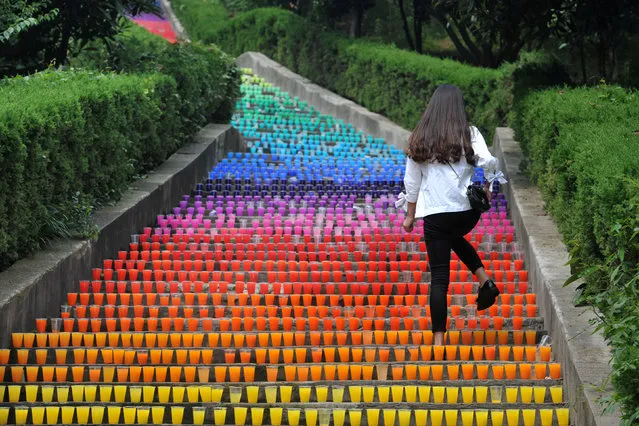 A woman walks on steps lined with plastic cups, an art project of four college students, in Wuhan, Hubei Province, China, May 24, 2016. (Photo by Reuters/Stringer)