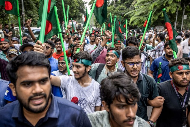 Protesters hold Bangladesh's national flags as they march to block the house of Sheikh Mujibur Rahman, “Bangabandhu” the first president of independent Bangladesh and father of ousted ex-premier Sheikh Hasina, in Dhaka on August 15, 2024, to mark the anniversary of his assassination. August 15 is the anniversary of the 1975 assassination of her father, independence hero Sheikh Mujibur Rahman, during a military coup -- a date her government had declared a national holiday. Previous years saw huge rallies around Bangladesh to mark the occasion, but the students who toppled Hasina were eager to ensure supporters of her Awami League party did not have a chance to regroup. (Photo by Luis Tato/AFP Photo)