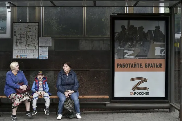 People sit at a bus stop decorated by a letter Z, which has become a symbol of the Russian military in Sevastopol, Crimea, Thursday, May 5, 2022. (Photo by AP Photo/Stringer)