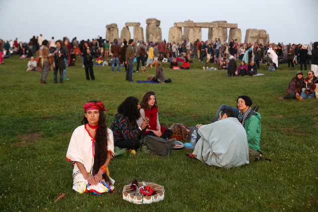 People watch the sun rise on the Stonehenge monument on the summer solstice near Amesbury, Britain on June 21, 2017. (Photo by Neil Hall/Reuters)