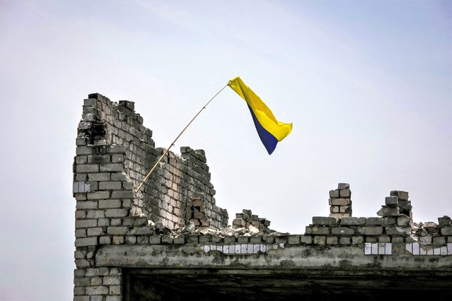 A Ukrainian national flag is seen, amid Russia's attack on Ukraine, near the front line in the newly liberated village Neskuchne in Donetsk region, Ukraine on June 13, 2023. (Photo by Oleksandr Ratushniak/Reuters)