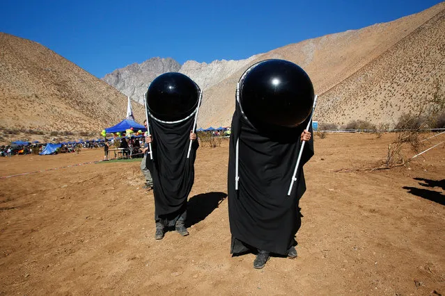 Chileans watch the sky with special suits prior to a total solar eclipse on July 2, 2019 in Paiguano, Chile. Around 25,0000 tourists arrived to Paiguano, a small town of around 1,000 inhabitants in the Elqui Valley, 650 km away Santiago. This is the only Earth's total solar eclipse of 2019 and the first one since 2017. From this point, the sun will fully disappear for around two minutes. It is best visible from a stripe in the South Pacific, Chile and Argentina. (Photo by Marcelo Hernandez/Getty Images)