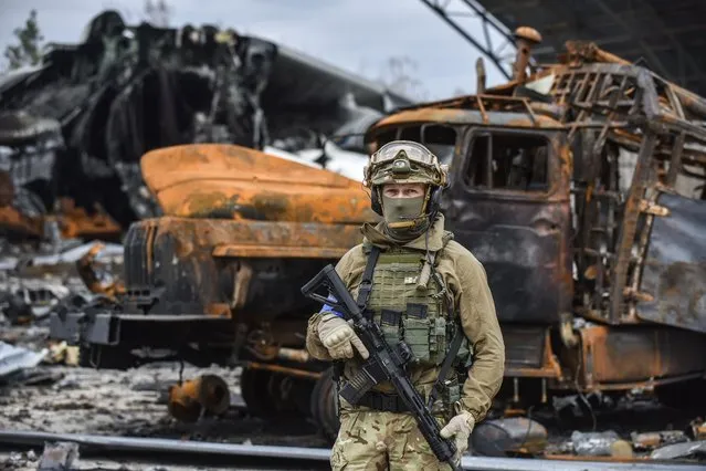 A Ukrainian special forces officer stands near a damaged hangar containing the wreckage of the world's largest plane, the Ukrainian cargo Antonov An-225 Mriya “Dream”, at the Gostomel airfield near Kyiv (Kiev), Ukraine, 08 April 2022. The plane was destroyed amid the ongoing Russian invasion of Ukraine. (Photo by Oleg Petrasyuk/EPA/EFE)