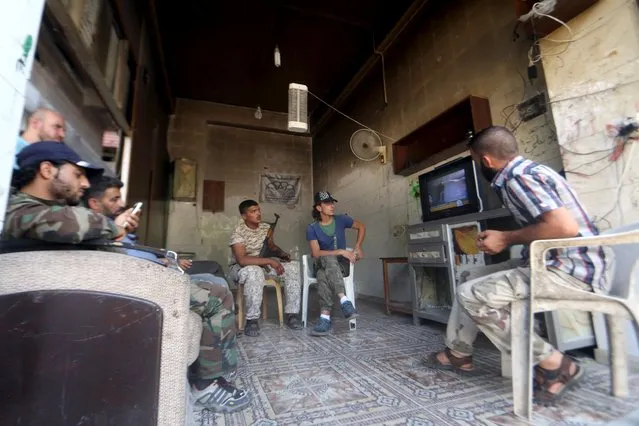 “Free Syrian Army” fighters watch television while resting in Aleppo, Syria August 10, 2015. (Photo by Abdalrhman Ismail/Reuters)