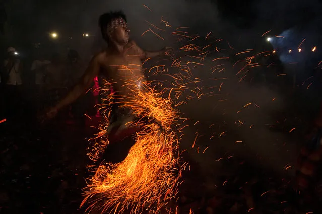 A Balinese Hindu runs through burning coconut husks during a “Mesabatan Api” ritual on the eve of Nyepi, a day of silence for self-reflection to celebrate the new year, in Gianyar, Bali, Indonesia March 27, 2017. (Photo by Nyoman Budhiana/Reuters/Antara Foto)
