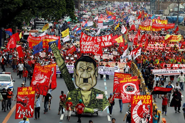Thousands of protesters march towards the Lower House with an effigy of President Rodrigo Duterte, lower right, to demand that he deliver on a wide range of promises he made in his first state of the nation address last year, from pressing peace talks with Marxist guerrillas, which is currently on hold, to upholding human rights and the rule of law Monday, July 24, 2017 at suburban Quezon city, northeast of Manila, Philippines. It was the first time that the leftist protesters have displayed an effigy of Duterte. (Photo by Erik De Castro/Reuters)