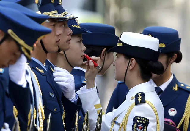 A female honor guard has lipstick applied as they prepare for an official welcoming ceremony outside the Great Hall of the People in Beijing. (Photo by Jason Lee/Reuters)