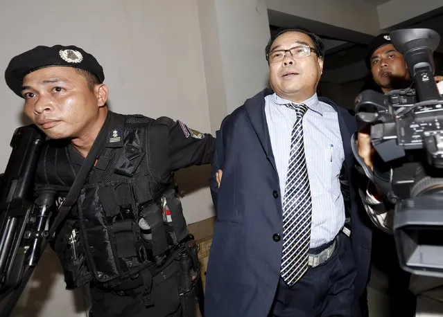 Senator Hong Sok Hour (C) of the opposition Cambodia National Rescue Party (CNRP) arrives at the Municipal Court of Phnom Penh August 15, 2015. The prominent Cambodian opposition senator who angered Prime Minister Hun Sen with a Facebook posting of a phoney pledge to dissolve the border with Vietnam has been arrested and will be charged with treason, a government spokesman said. (Photo by Samrang Pring/Reuters)