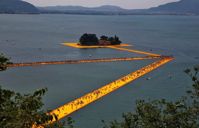 People walk on the installation “The Floating Piers” by Bulgarian-born artist Christo Vladimirov Yavachev, known as Christo, at the installation's last weekend near Sulzano, northern Italy, July 2, 2016. (Photo by Wolfgang Rattay/Reuters)