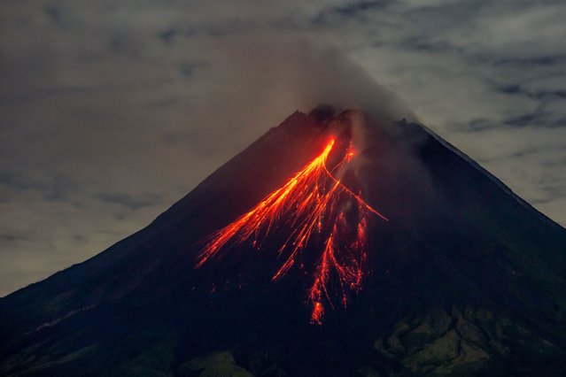 Mount Merapi spews lava onto its slopes during an eruption as seen from Srumbung village in Magelang, Central Java, on November 4, 2024. (Photo by Devi Rahman/AFP Photo)