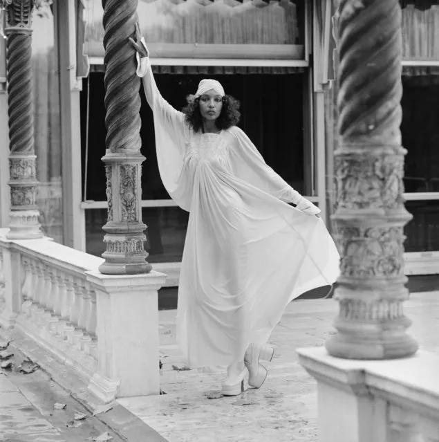 A model wearing a full-length white dress with matching hat, at a show by British designers Bill Gibb, John Bates, Jean Muir and Zandra Rhodes, at Les Ambassadeurs, London, 27th October 1972