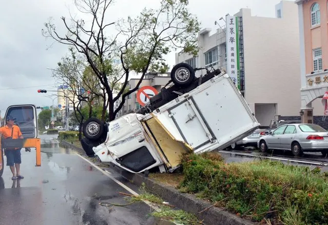 A truck lays upside down on a traffic divider after being blown over by strong winds in the Taiwanese city of Taitung on July 8, 2016 after Super Typhoon Nepartak passed over the island. (Photo by AFP Photo)