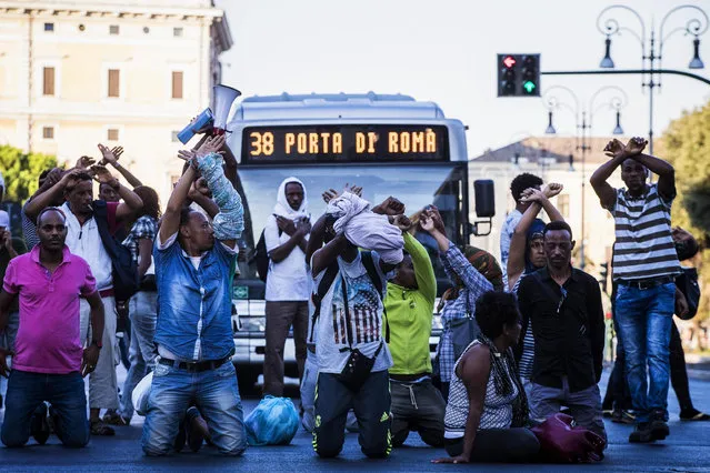 Migrants protest as they are forced to leave the area around a building they were occupying, in downtown Rome, Thursday, August 24, 2017. Protests erupted as police continued an operation to evict some 800 Eritrean and Ethiopian refugees from a building they have occupied since 2013, despite protests from the U.N. refugee agency, UNICEF, and humanitarian organizations. (Photo by Angelo Carconi/ANSA via AP Photo)