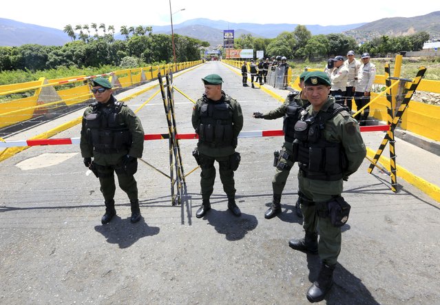 Colombian policemen stand guard at the Simon Bolivar border bridge with Venezuela, near Villa del Rosario village, Colombia, August 25, 2015. (Photo by Jose Miguel Gomez/Reuters)