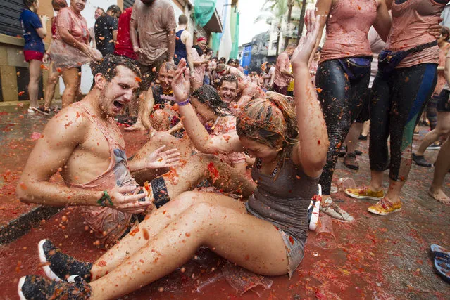 Revellers covered in tomato pulp take part in the annual “Tomatina” festival in the eastern town of Bunol, on August 30, 2017. (Photo by Jaime Reina/AFP Photo)