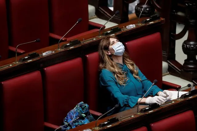 Deputy Maria Teresa Baldini of Fratelli d'Italia party (Brothers of Italy) wears a protective mask and gloves inside the low house parliament building after Italy orders a lockdown on the whole country aimed at beating the coronavirus, in Rome, Italy, March 11, 2020. (Photo by Remo Casilli/Reuters)