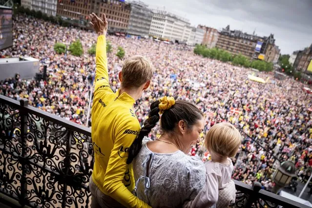Danish rider Jonas Vingegaard (L) of Team Jumbo-Visma wearing the overall leader's yellow jersey is accompanied by his wife Trine Maria Hansen (C) and their daughter Frida (R) during a reception on the balcony of the City Hall in central Copenhagen, Denmark, 27 July 2022. Vingegaard returned to Denmark after winning the Tour de France 2022 in the final stage on the Champs-Elysees in Paris, France, on 24 July 2022. (Photo by Mads Claus Rasmussen/EPA/EFE)