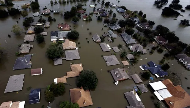 Floodwaters reach the roofs of homes in Braithwaite, Louisiana on Friday. (Photo by David J. Phillip/Associated Press)