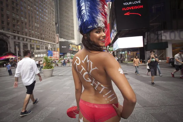 A model who poses for tips wearing body paint and underwear poses for a portrait in Times Square in New York, August 19, 2015. She declined to give her name. New York City created a task force on Thursday to examine how it can rein in topless women and costumed cartoon and superhero characters who officials believe are aggressively soliciting tips after posing for tourists' pictures in Times Square. (Photo by Carlo Allegri/Reuters)