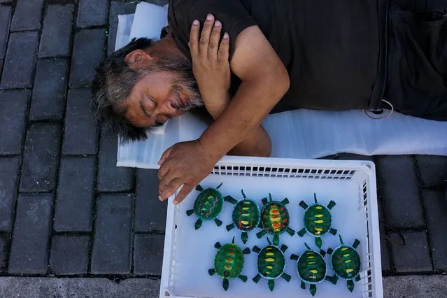 A Chinese roadside salesman takes a rest in the old quarters in Shanghai on September 13, 2017. (Photo by Chandan Khanna/AFP Photo)