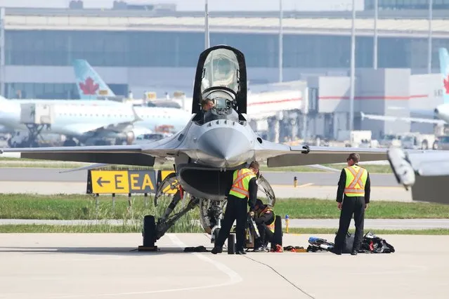 Airport personnel secure an F-16C Fighting Falcon from the 79th Fighter Squadron, Shaw Airforce Base, South Carolina, during media day for the Canadian International Air Show at Pearson Airport in Toronto, Ontario, September 3, 2015. (Photo by Louis Nastro/Reuters)