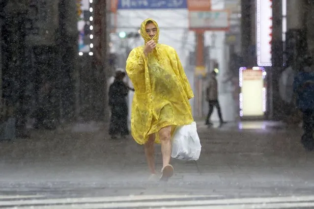 A man makes his way through the heavy rain caused by a powerful typhoon in Kagoshima, southern Japan, Sunday, September 18, 2022. (Photo by Kyodo News via AP Photo)