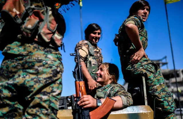 Kurdish female fighters of the Syrian Democratic Forces (SDF) gather during a celebration at the iconic Al- Naim square in Raqa on October 19, 2017, after retaking the city from Islamic State (IS) group fighters. (Photo by Bulent Kilic/AFP Photo)