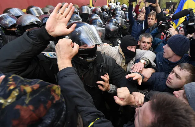 People clash with Ukrainian riot policemen during a demonstration of opposition's supporters in front of the Ukrainian Parliament, in Kiev, on October 22, 2017. Some 2,000 of disgruntled Ukrainian activists, headed with former Georgian president Mikheil Saakashvili, gathered in a tent camp outside parliament to demand a more forceful fight against government graft. (Photo by Sergei Supinsky/AFP Photo)
