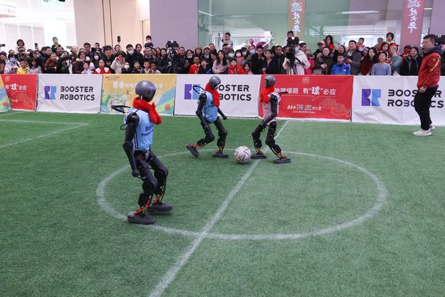 People watch a soccer game given by robots during the Spring Festival Science and Technology Temple Fair on January 30, 2025 in Beijing, China. The temple fair kicked off January 30, with the main venue located at Wukesong Wanda Plaza, inviting visitors to take a close look at the latest achievements in the AI field during Spring Festival, or the Chinese New Year. (Photo by Chen Xiaogen/VCG via Getty Images)