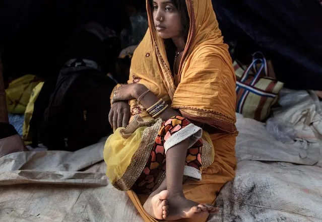 Rinku Yadav, aged 20, breast feeds her two-year-old daughter after she was rid of the evil spirit she was believed to have been possessed with during the Ghost Festival at the banks of Kamala River in Dhanusha district, Nepal, 04 November 2017. Rinku's husband has migrated to Kuwait for a labor job one year ago. (Photo by Narendra Shrestha/EPA/EFE)