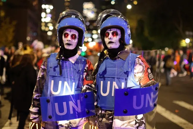 People attend New York's Annual Village Halloween Parade dressed as soldiers from the United Nations in Manhattan, New York City, U.S., October 31, 2022. (Photo by Andrew Kelly/Reuters)
