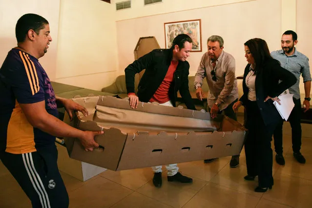 Alejandro Blanchard (C) introduces a cardboard coffin to potential customers at a mortuary in Valencia, in the state of Carabobo, Venezuela August 25, 2016. (Photo by Marco Bello/Reuters)