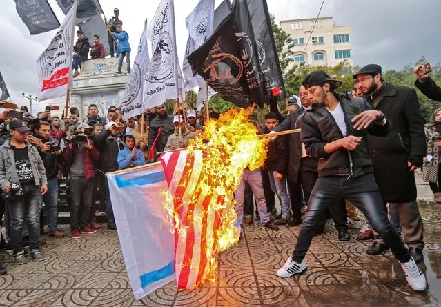 Palestinian protesters burn the U.S. and Israeli flags in Gaza City on December 6, 2017. (Photo by Mahmud Hams/AFP Photo)