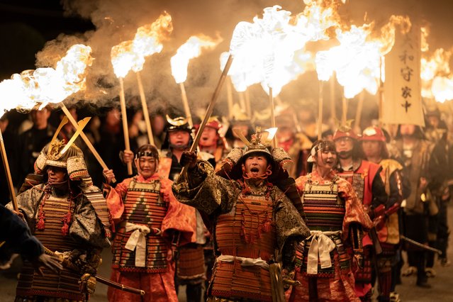 People dressed in samurai warrior costumes hold flaming torches as they march during the Kanoukaen Fire Festival at night on March 29, 2025 in Unzen, Nagasaki Prefecture, Japan. The fire festival which is based on a story depicted in a historical scroll over 400 years old was held in the cherry blossom season in the country. (Photo by Tomohiro Ohsumi/Getty Images)