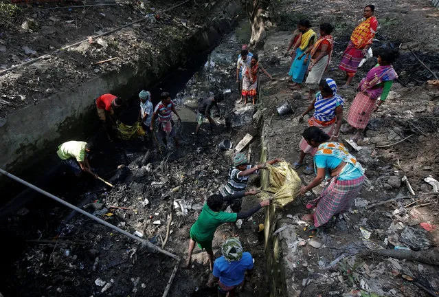 Labourers clean an open drain in Kolkata, India on January 5, 2018. (Photo by Rupak De Chowdhuri/Reuters)