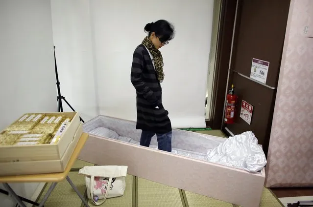Natsumi Niki stands in a coffin before lying down in it to test it during an end-of-life seminar held by Japan's largest retailer Aeon Co in Tokyo October 24, 2014. (Photo by Toru Hanai/Reuters)